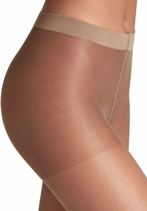 Nahaufnahme einer Person, die transparente, braune Strumpfhosen mit einem beigen Bund trägt, wobei die Stoffstruktur und Passform am oberen Oberschenkel und an der Taille hervorgehoben werden.