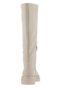 Beige lærknesk, med glidelås på siden, strukturert overflate og såle med riller for godt feste. Har en jevn finish og diskret søm.