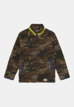 Fleecejacke mit braun-grünem Camouflage-Muster, gelbem Kragenbesatz, blauem Reißverschluss und Taschenkanten sowie einem kleinen weißen Etikett am Saum.