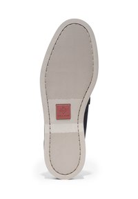 Suola di scarpa nera in gomma con superficie testurizzata e scanalature orizzontali. Presenta un'etichetta di marchio rettangolare con "Cole Haan" in rosso.