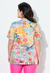 Kleurvolle grafische t-shirt met een strandthema, versierd met bloemenpatronen, zeesterren en tekstaccenten; gemaakt van zachte stof, kort mouw ontwerp.