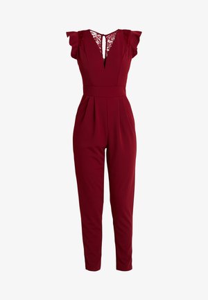 Burgundi jumpsuit pitsilöögi aksentidega õlgadel, V-kaelusega, pleeditud ees ja kitsaste jalgadega, valmistatud pehmest kangast, millel on sile tekstuur.