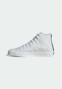High-top white canvas sneaker with silver eyelets, rubber sole, reinforced toe cap, textured side panel, and contrasting black back accent.