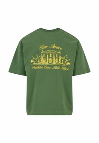 Zöld pamut póló rövid ujjakkal, sárga nyomtatott grafikával egy épületről, amelyen a "Ciao Amore" és a "Prohibited, Casa Moda Milano" felirat található.