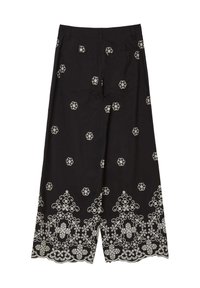 Schwarze weite Hosen mit weißer floralem Stickerei, ausgestattet mit einem gewellten Saum und zwei Gesäßtaschen. Hergestellt aus einem glatten Stoff.
