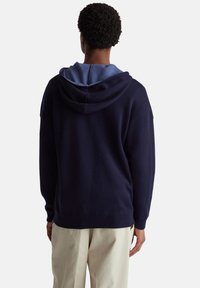 Marineblauwe hoodie met een lichtblauwe binnenkap. Gemaakt van zachte stof, met een relaxed fit en geribbelde manchetten en zoom.