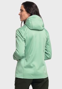 Minzgrüne Kapuzenjacke mit weicher Textur, die ein tailliertes Design, lange Ärmel und dezente Branding auf dem Ärmel aufweist.