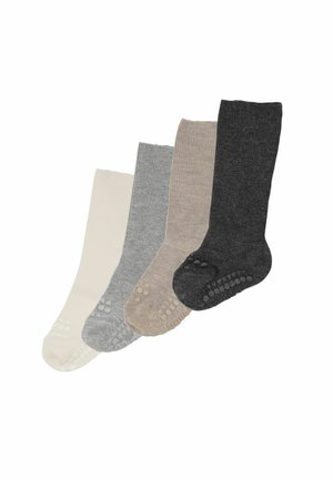 Quattro paia di calzini con grip al ginocchio in crema, grigio chiaro, beige e grigio scuro, disposti in una linea diagonale discendente.