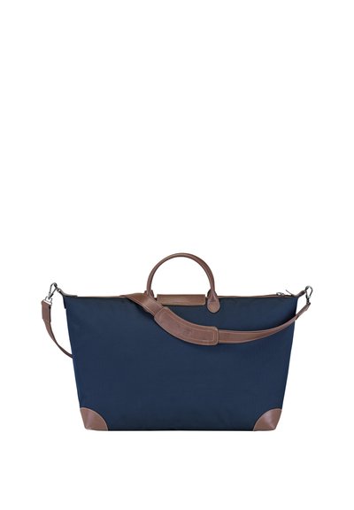 Marineblaue Stofftasche mit braunen Lederelementen und -griffen, breiter Form, abnehmbarem Schultergurt und strukturierten Details.