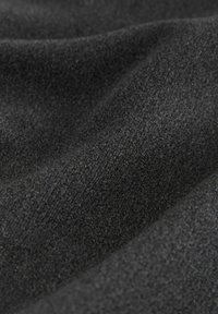 Tissu noir à finition texturée, présentant une surface douce et lisse. Les couches créent des plis délicats, mettant en valeur la tombée et la qualité du matériau.