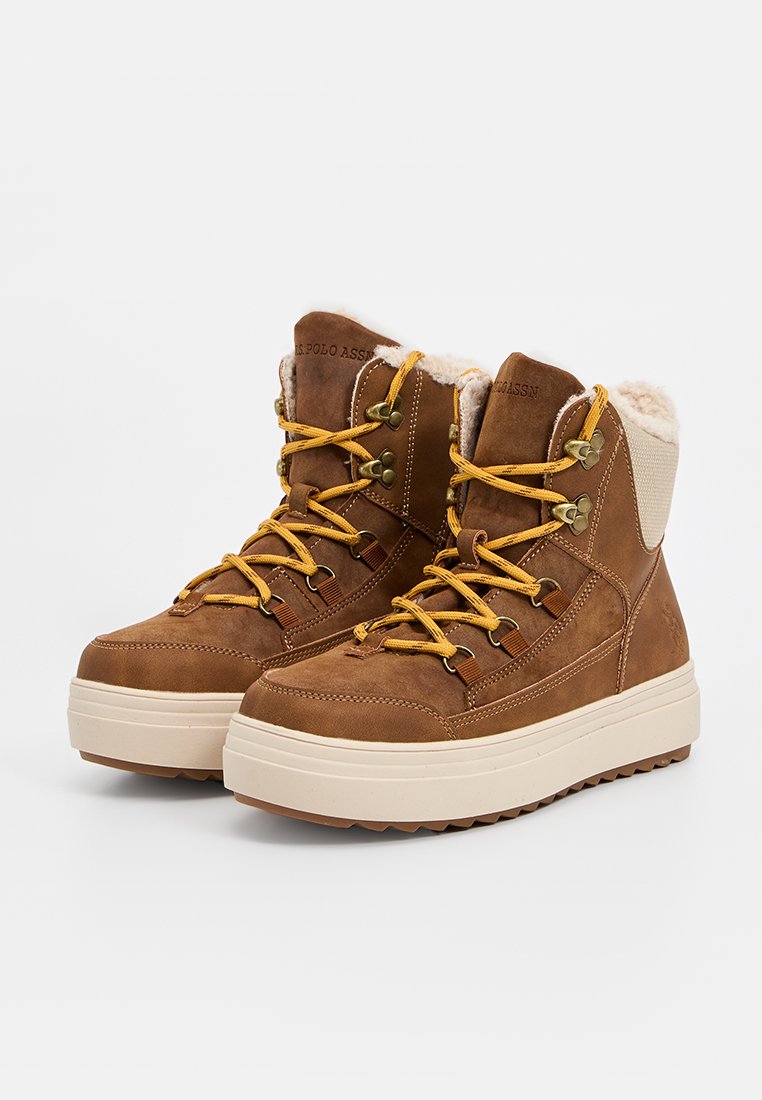 Braune Lederwanderschuhe mit gelben Schnürsenkeln, gepolstertem Kragen und beigen Akzenten. Dicke cremefarbene Sohle mit strukturiertem Profil für besseren Halt.