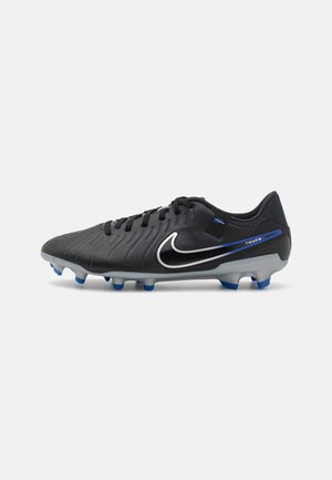 Bota de fútbol Nike Tiempo en negro y azul con cordones, parte superior texturizada, logo Swoosh blanco y tacos cónicos en suela gris.