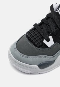 Sneaker nero e grigio con dettagli in rete, camoscio testurizzato, suola in gomma, accenti bianchi e un cappuccio del piede liscio con dettagli maculati.