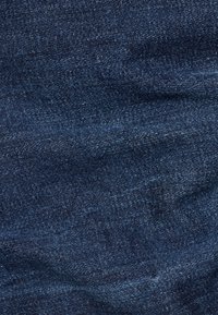 Mörkblå denimtyg med en slät struktur och subtila nyansvariationer, typiska för vävda textilmönster.