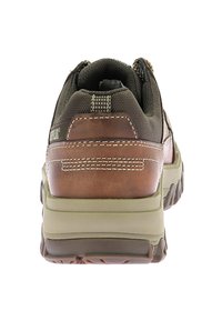 Zapatilla deportiva de cuero marrón y malla con una superficie texturizada, cuello acolchado y suela de goma; presenta costuras en contraste y un diseño resistente.