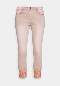 Jeans de mezclilla rosa claro con intrincados bordados en paisley naranja en el dobladillo y costuras decorativas en los bolsillos frontales. Corte de talle medio.