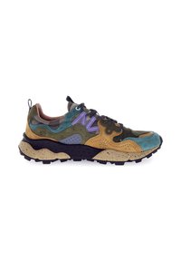 Sneaker da trail robusta con pannelli in suede verde, blu, beige e viola, suola maculata nera e beige, e lacci neri con punti bianchi.