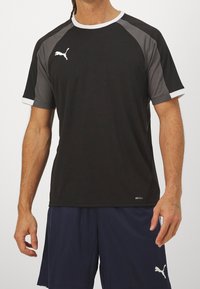 Black athletic shirt with gray accents, round crew neck, and short sleeves. Features moisture-wicking DRYCELL technology and logo detail.