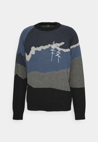 Pull à col rond avec un motif de montagnes bleu, gris et noir, et deux arbres blancs brodés sur la poitrine et les manches.