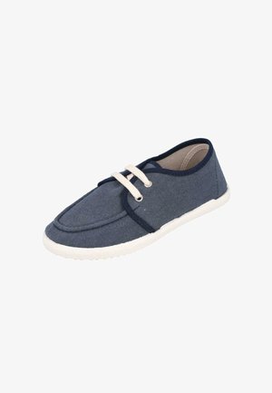 Zapato casual de tela azul marino con suela de goma blanca y cordones blancos, diseño de corte bajo y ribete oscuro alrededor de la abertura.