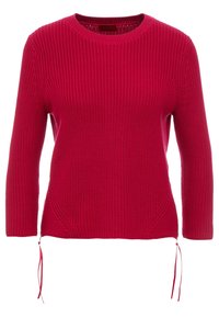 Czerwony sweter na drutach z okrągłym dekoltem, rękawami o długości do połowy przedramienia oraz bocznymi detalami ze sznurkiem. Faktura prążkowana i luźny krój.