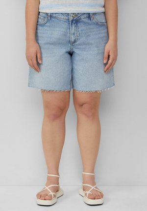 Light blue denim shorts with a frayed hem, featuring a classic five-pocket design and a front button closure. Worn with white strappy sandals.