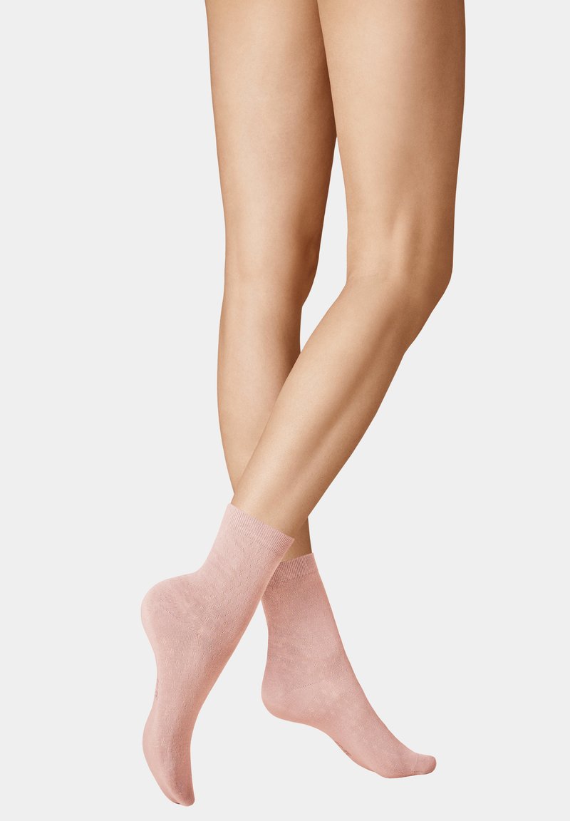 Pink ankle socks made of a soft, textured fabric with a ribbed cuff, featuring a subtle pattern for added detail.