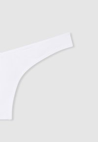 Tanga bianco con una texture liscia e cuciture minime. Presenta una vita sottile e una forma curvilinea, progettata per una copertura minima.