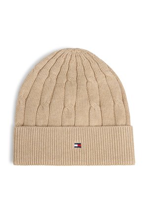 Gorro bege de malha com padrões de trança e punho canelado dobrado, com um pequeno logótipo retangular vermelho, branco e azul na parte frontal ao centro.
