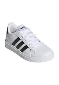 White leather sneaker with black three-stripe design, round toe, lace-up closure, textured rubber sole, and padded collar.