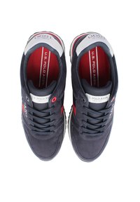 Navy suede tennarit punaisilla yksityiskohdilla, valkoinen logo-otsake ja teksturoitu nauhakiinnitys. Varustettu pehmustetulla pohjallisella ja kumipohjalla.