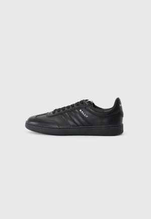 Black leather sneaker with a rounded toe, six eyelets, textured side stripes, and a rubber sole. "BALLY" logo on the side and heel.
