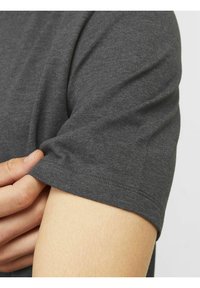 Graues Baumwoll-T-Shirt mit kurzen Ärmeln, das eine glatte Textur und ein einfaches Design zeigt. Der Ärmelsaum ist sauber verarbeitet.