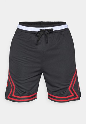 Shorts de sport noirs avec taille élastique blanche et cordon noir, comportant des lignes géométriques rouges et des logos près des ourlets sur les deux jambes.