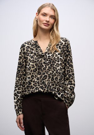 Blouse en léopard beige et noir, avec un col en V, des manches longues et une coupe décontractée. Fabriquée en tissu léger et lisse.