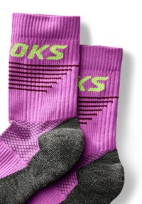 Calcetines deportivos rosas con textura acanalada, que presentan un logo verde, acentos en el talón y la punta en gris oscuro, y patrones geométricos en la zona del pie.
