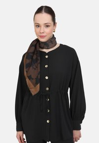 Black button-up shirt with a cinched waist, featuring gold buttons. Brown scarf with a floral pattern wrapped around the neck. Smooth texture.