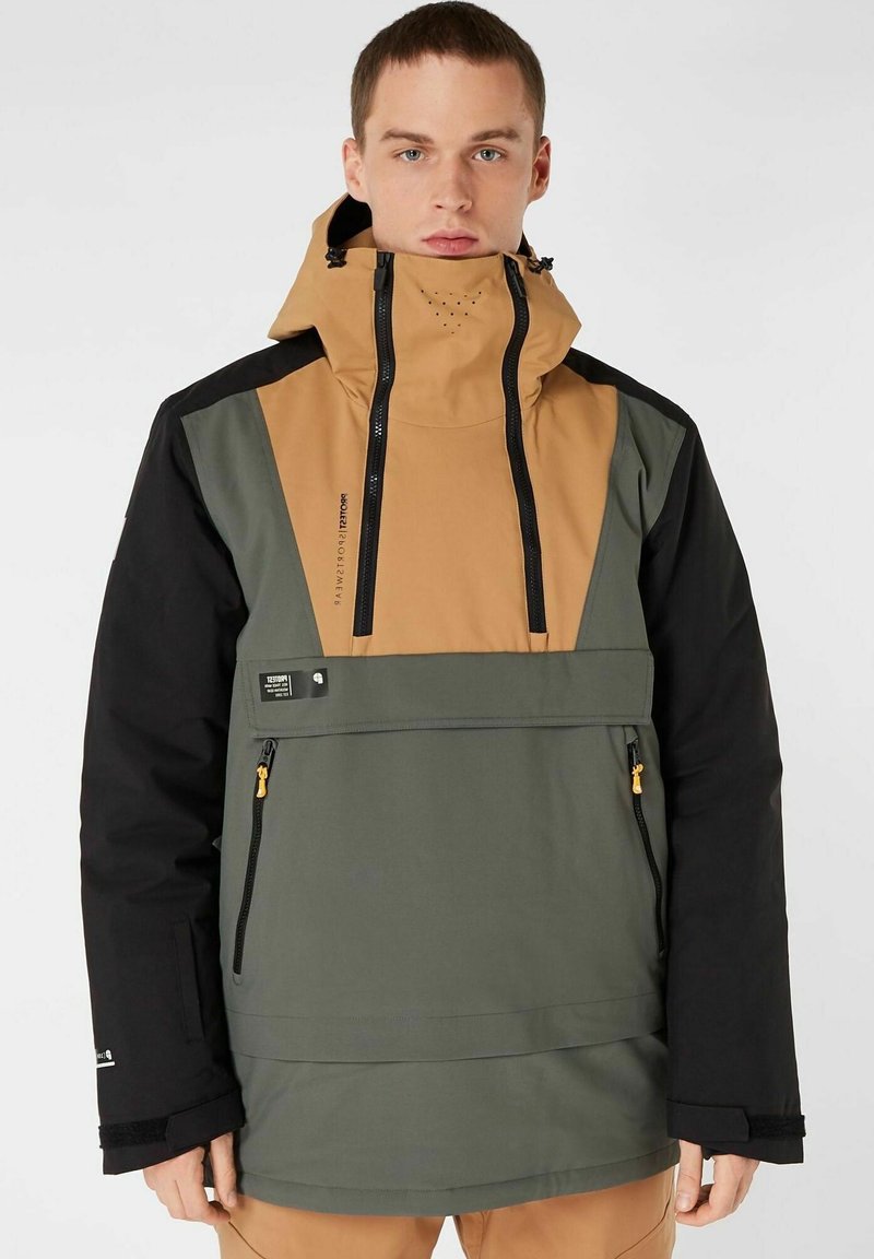 Herren-Anorakjacke mit einem Farbblockdesign in braunen, grünen und schwarzen Materialien. Verfügt über einen hohen Kragen, Reißverschlusstaschen und eine verstellbare Kapuze.