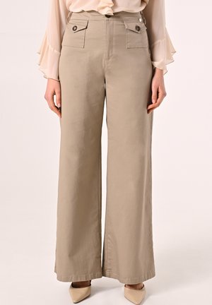 Pantaloni larghi beige realizzati in leggero tessuto, dotati di due tasche frontali con chiusura a bottone e un design pulito e semplice.