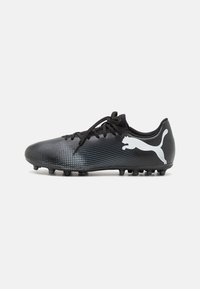 Botín de fútbol negro con superficie texturizada y diseño en degradado, que presenta cordones negros y un logo de Puma blanco en el lado exterior.