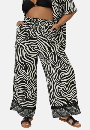 Black and white zebra-striped wide-leg pants with an elastic waistband, featuring side pockets and a patterned hem. Lightweight material.