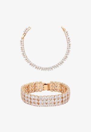 Ruusukultaiset rannekorut, joissa on kirkkaat strassit; toinen on joustava ketjumalli, toinen jäsennelty monirivinen rakenne.