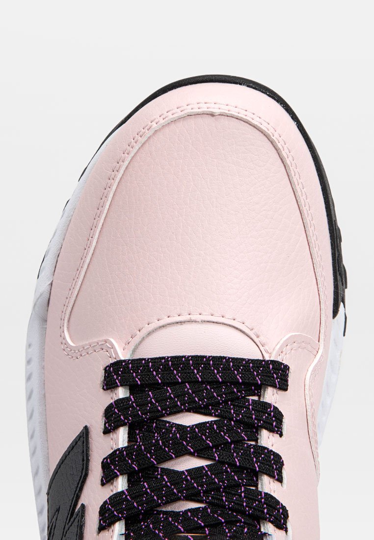 Sneaker in pelle rosa con accenti neri, caratterizzata da un materiale testurizzato, lacci viola e neri, e una suola bianca che mostra una silhouette distintiva.