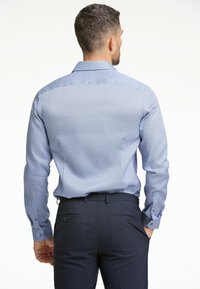 Lichtblauw gemusterd overhemd met lange mouwen, voorzien van een knoopsluiting en een normale kraag, gecombineerd met donkere broeken.