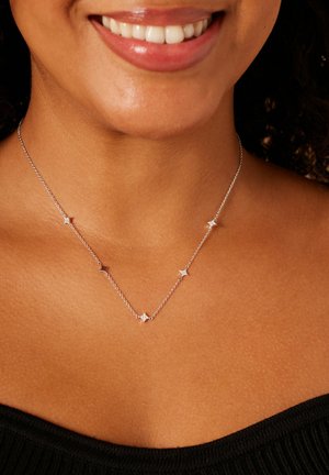 Zilveren ketting met stervormige hangers verspreid over de ketting. Het ontwerp is delicaat met een gepolijste afwerking.