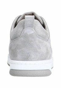 Grijze suède sneaker met een zachte textuur, afgeronde vorm, witte zool en contrasterende grijze buitenzool. Achteraanzicht legt de nadruk op het minimalistische ontwerp.