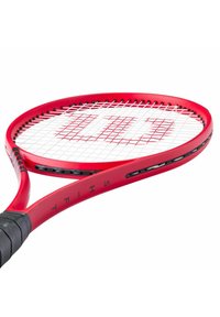 Rode tennisracket met een ronde kop, een witte snaarbed en een zwarte grip. Beschikt over een slank ontwerp met branding op het frame.