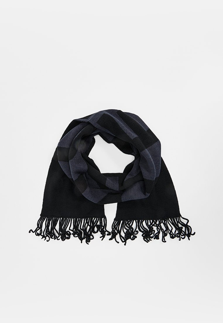 Écharpe en noir et bleu marine à carreaux, fabriquée en tissu doux, avec des bords à franges et un design en boucle pour un port facile.