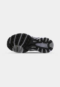 Black and gray athletic shoe sole featuring rubber tread, grooves for traction, and a reinforced heel design. Textured for grip and durability.