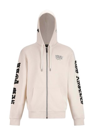Lichtbeige rits hoodie met een voorvak, trekkoordkap, zwarte grafische letters op de mouwen en een klein logo op de borst.